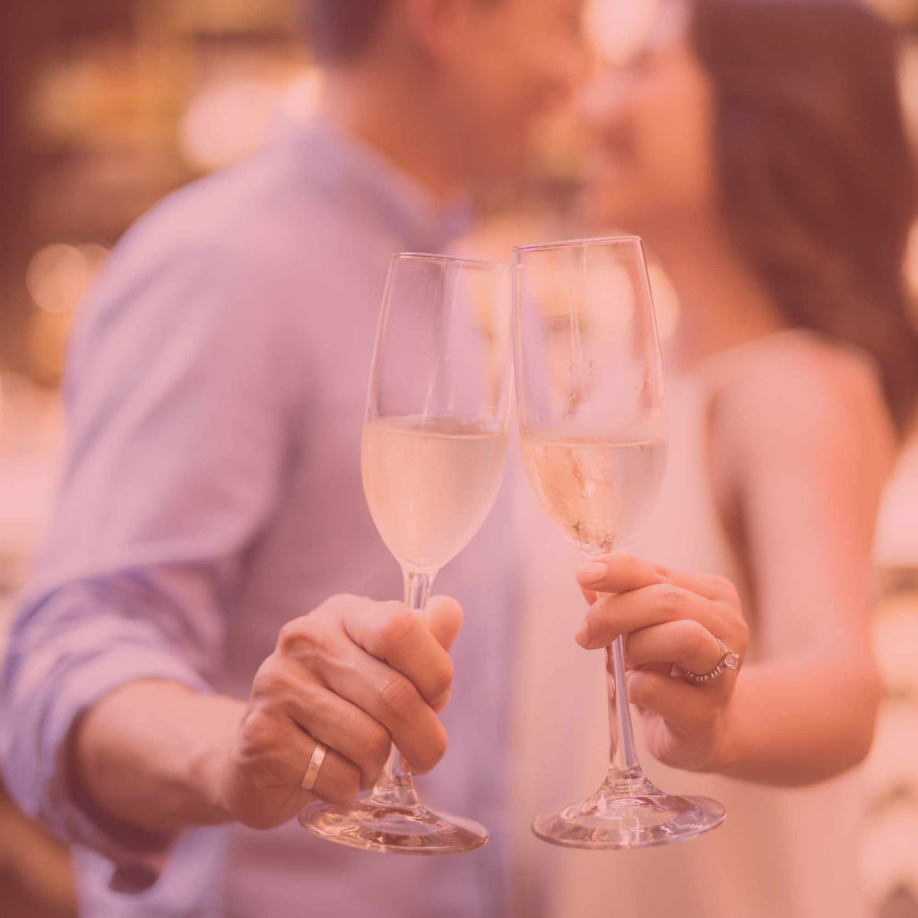 Casal a brindar com Champagne em jantar romântico